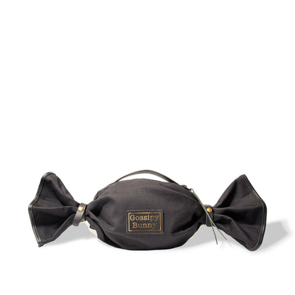 ROAVAN（ローバン） Gossipy Bunny（ゴシッピーバニー） Bonbon Lop（ボンボン・ロップ）のキャンディ形バッグ。岡山県倉敷産11号帆布と国産ブラックレザーを組み合わせ、両端をツイストして束ねた立体構造と真鍮金具、黒ファスナーを採用したショルダー兼ハンドバッグ。