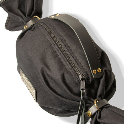 ROAVAN（ローバン） Gossipy Bunny（ゴシッピーバニー） Bonbon Lop（ボンボン・ロップ）のキャンディ形バッグ。岡山県倉敷産11号帆布と国産ブラックレザーを組み合わせ、両端をツイストして束ねた立体構造と真鍮金具、黒ファスナーを採用したショルダー兼ハンドバッグ。