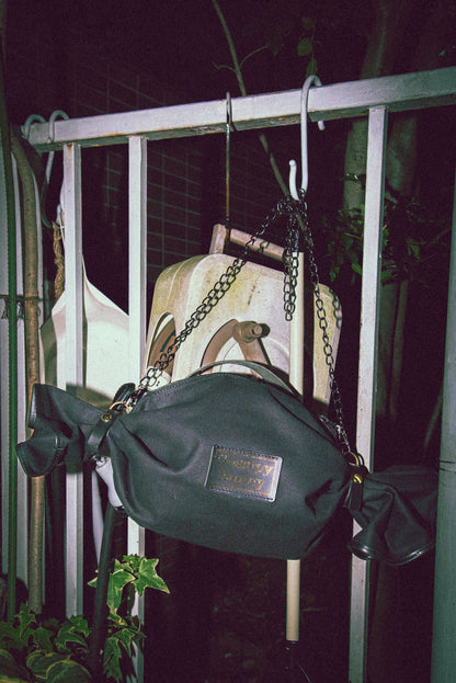 ROAVAN（ローバン） Gossipy Bunny（ゴシッピーバニー） Bonbon Lop（ボンボン・ロップ）のキャンディ形バッグ。岡山県倉敷産11号帆布と国産ブラックレザーを組み合わせ、両端をツイストして束ねた立体構造と真鍮金具、黒ファスナーを採用したショルダー兼ハンドバッグ。