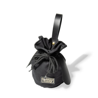 Roavan（ローバン） Gossipy Bunny（ゴシッピーバニー） Bunny Vup（バニーバップ） 巾着型ポーチ。倉敷帆布とブラックレザーの構成、丸底形状、SMロープ、本革ループハンドル、垂れ耳モチーフを特徴とする携行用小型ポーチ。
