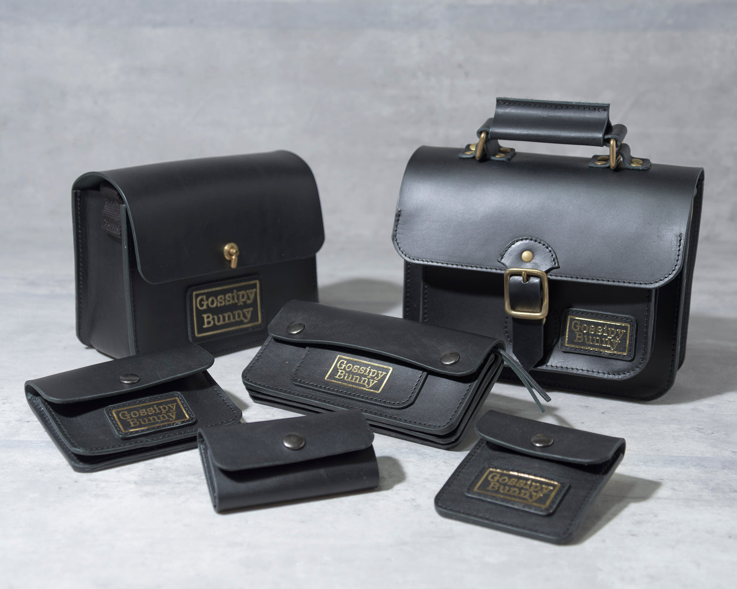 Roavan（ローバン） Gossipy Bunny（ゴシッピーバニー）のレザーアイテム集合写真。黒の牛ヌメ革と真鍮パーツを使用したバッグやキーケース、コインケースなどが並び、遊び心と上質感を感じさせる日本製の革小物ブランド。