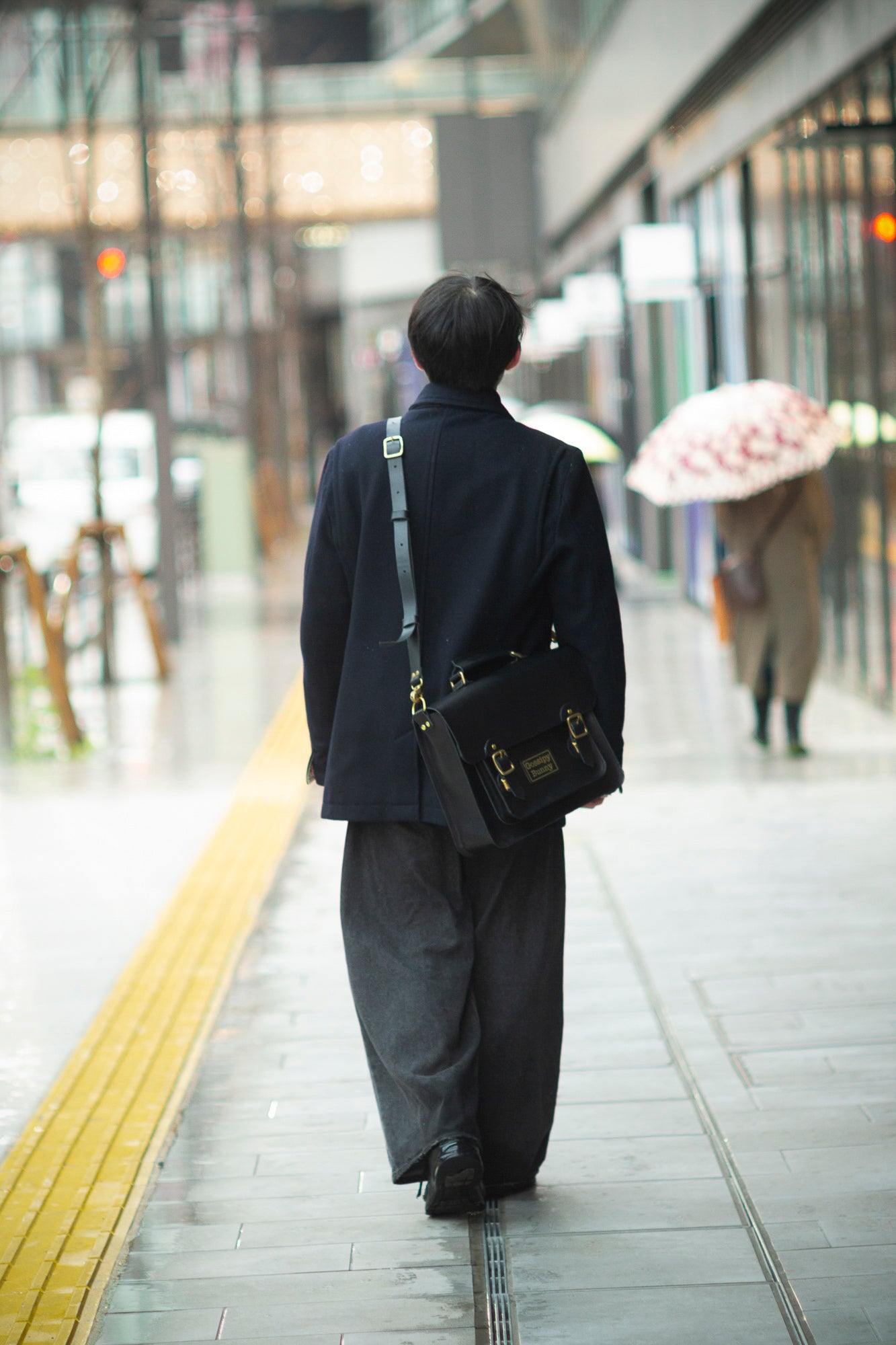 Roavan（ローバン）／RASWING（ラスウィング）／Gossipy Bunny（ゴシッピーバニー）のレザーバッグをモデルが実際に使用しているイメージ写真。日常の動きの中で、日本製ブランドの上質さと使う姿の美しさを表現したギャラリーカット。