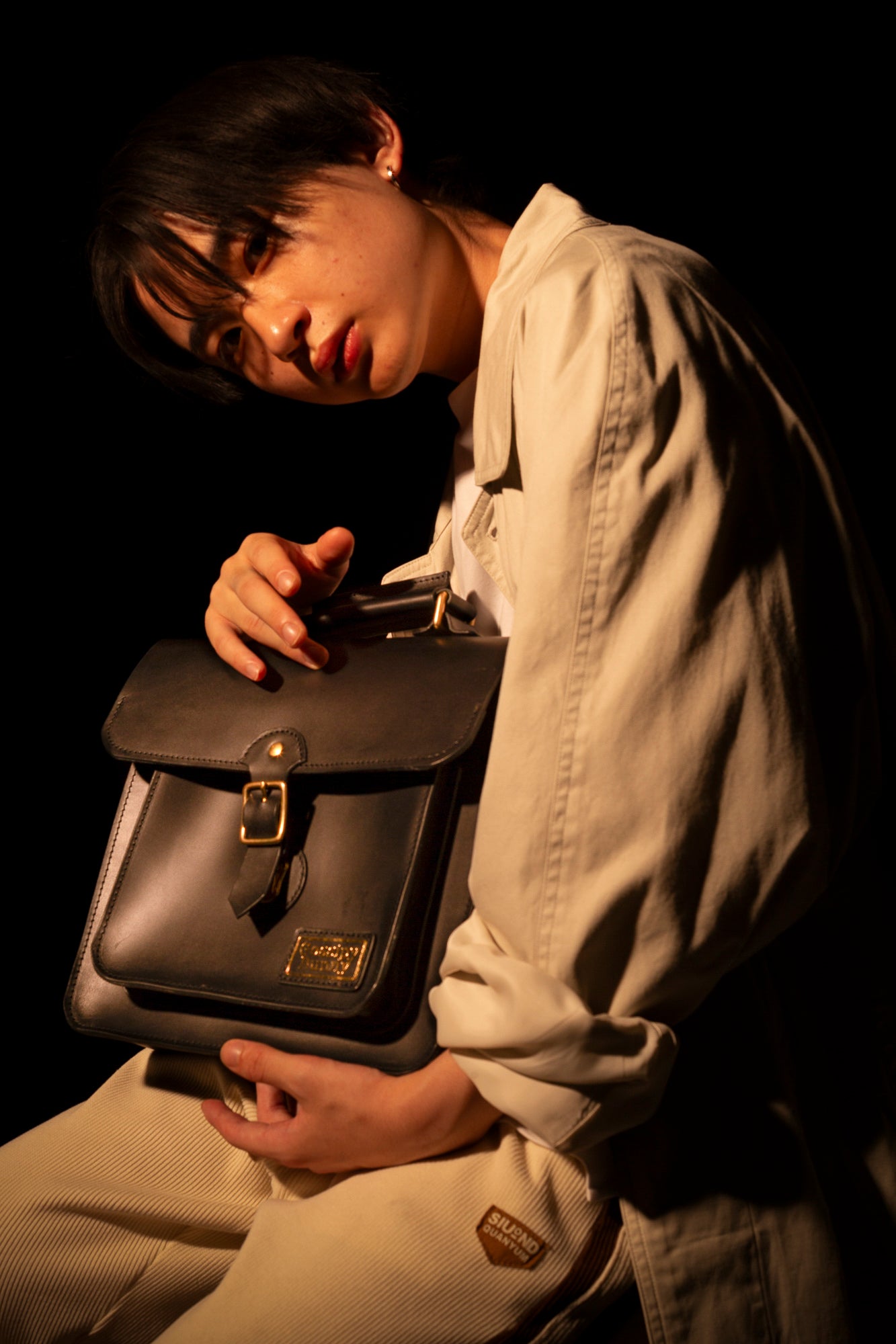 Roavan（ローバン）／RASWING（ラスウィング）／Gossipy Bunny（ゴシッピーバニー）のレザーバッグをモデルが実際に使用しているイメージ写真。日常の動きの中で、日本製ブランドの上質さと使う姿の美しさを表現したギャラリーカット。