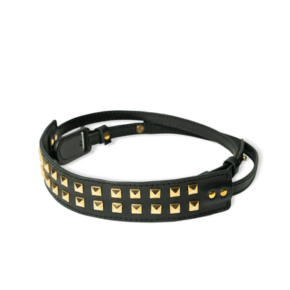 ROAVAN（ローバン） Gossipy Bunny（ゴシッピーバニー） Prick Dot（プリックドット） カメラストラップ。国産ブラックレザーを使用し、ゴールドカラーのピラミッド型スタッズを点在配置したデザイン。アンカーリンクスによるワンタッチ着脱と、首への負担を軽減する幅広ネック構造が特徴。