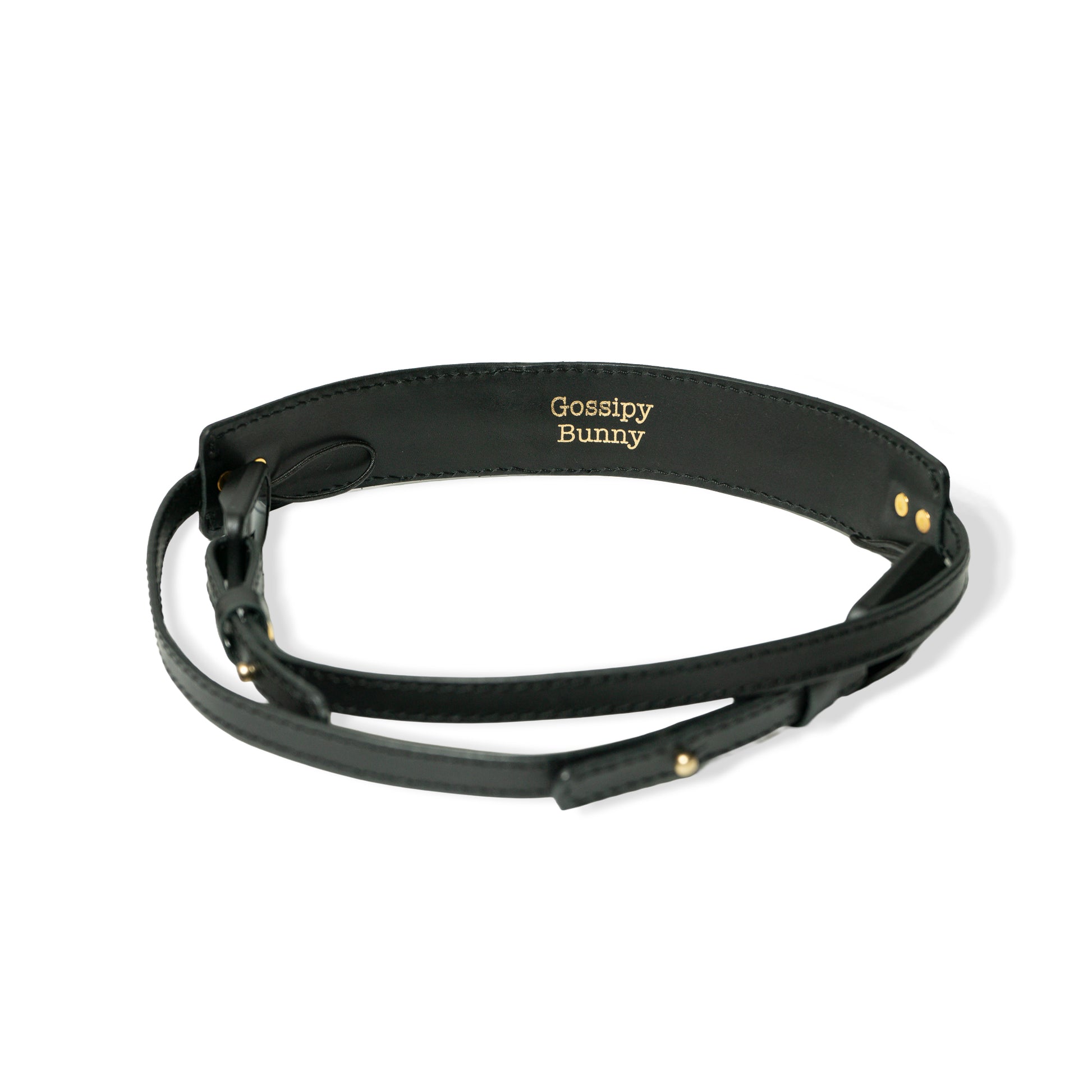 ROAVAN（ローバン） Gossipy Bunny（ゴシッピーバニー） Prick Dot（プリックドット） カメラストラップ。国産ブラックレザーを使用し、ゴールドカラーのピラミッド型スタッズを点在配置したデザイン。アンカーリンクスによるワンタッチ着脱と、首への負担を軽減する幅広ネック構造が特徴。
