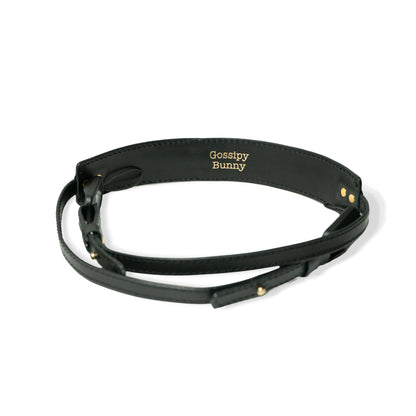 ROAVAN（ローバン） Gossipy Bunny（ゴシッピーバニー） Prick Dot（プリックドット） カメラストラップ。国産ブラックレザーを使用し、ゴールドカラーのピラミッド型スタッズを点在配置したデザイン。アンカーリンクスによるワンタッチ着脱と、首への負担を軽減する幅広ネック構造が特徴。