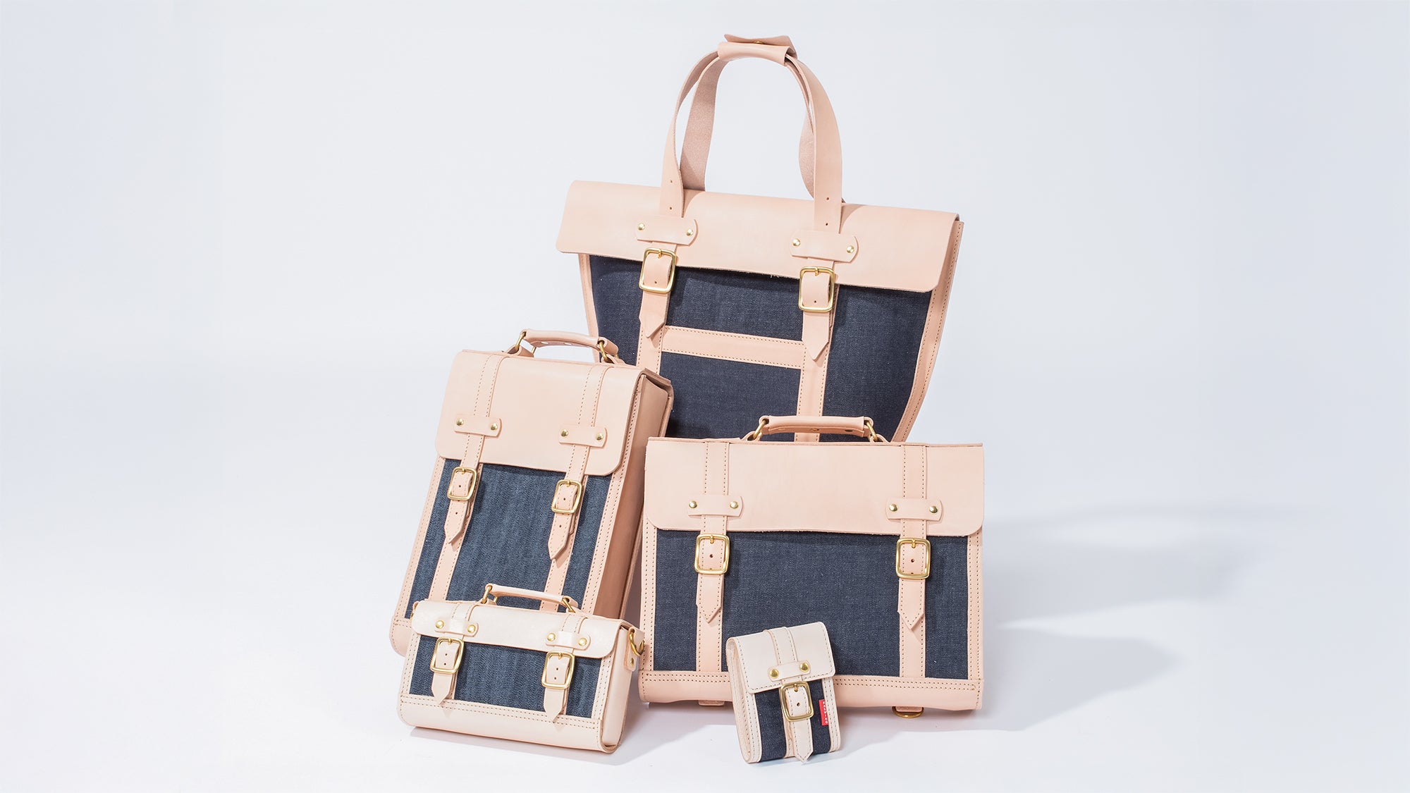 ROAVAN（ローバン） RASWING（ラスウィング）の公式集合写真。栃木レザーの生成りヌメ革、倉敷デニム、真鍮を組み合わせた受注生産の本革バッグと革小物のラインナップ。日本製素材と職人技を活かし、使うほどに艶が増して育つクラフトブランド。