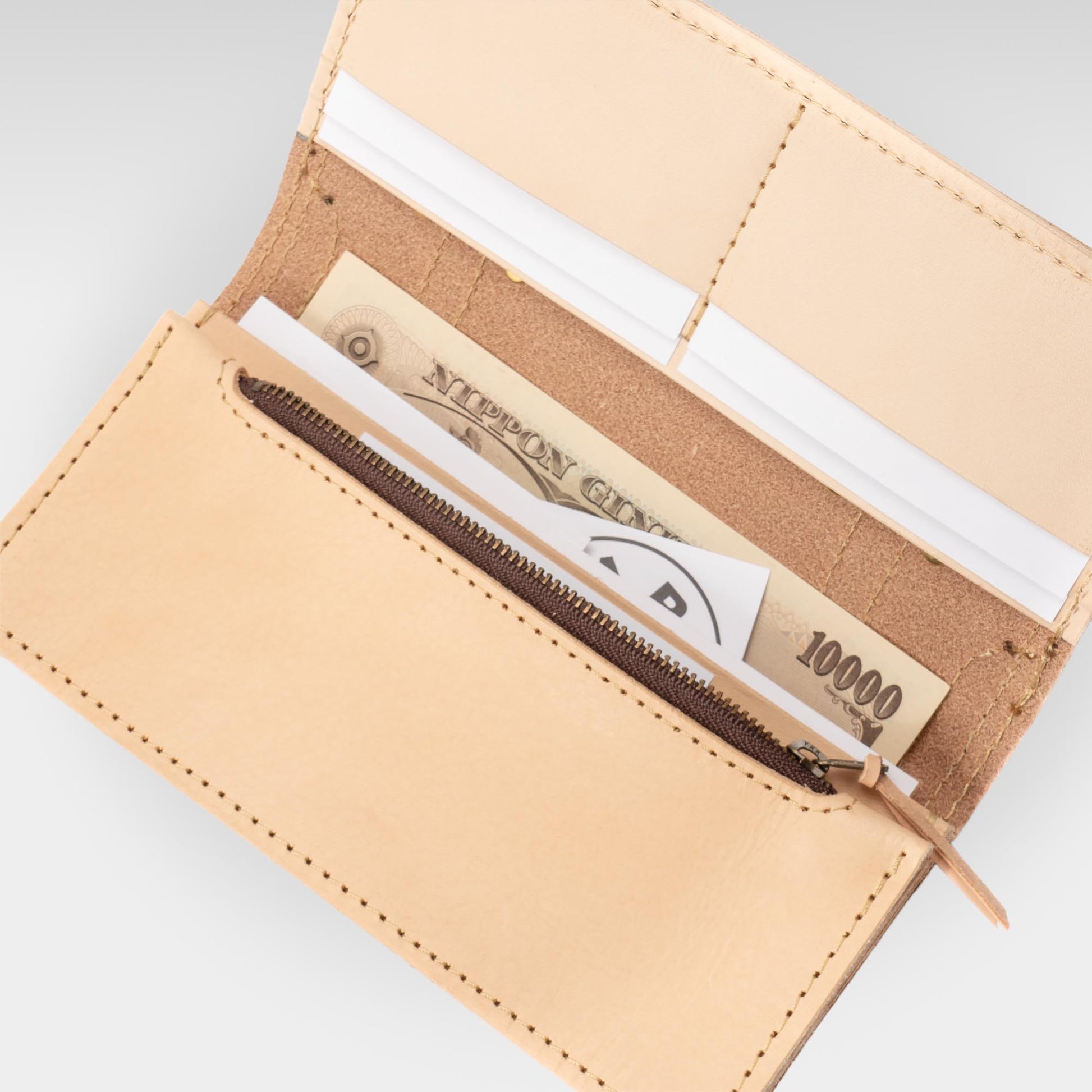 Roavan（ローバン） RASWING（ラスウィング） Tranaldo（トラナルド） 長財布。栃木レザーと倉敷デニム（ムラ糸）を使用した一枚革仕立ての堅牢なロングウォレット。トランクケースをモチーフに、職人が一点ずつ受注生産。時間とともに飴色に育つ本革と、美しいアタリが出るデニムが融合した、育てる楽しみを味わえる日本製財布。