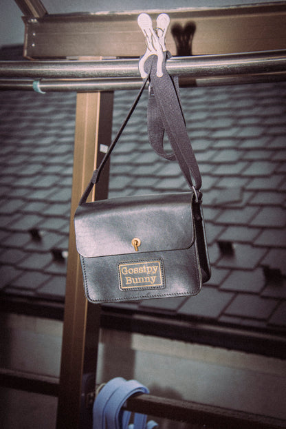 Roavan（ローバン） Gossipy Bunny（ゴシッピーバニー） Toy Box（トイボックス） ショルダーバッグ。国産ブラックレザーを使用した箱型一室構造で、真鍮製はとめ起こしによる片手開閉が可能な、散歩や日常の外出向けレザーバッグ。